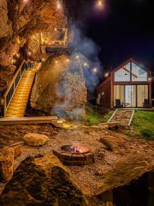 a fire pit in front of a house at night at Cliff Hot Tub with Deck Fire Pit Mural and Pet Friendly in Rogers