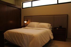 a bedroom with a large white bed with a window at Exclusive Boutique Apartment in Mérida Norte in Mérida +45 photos