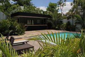 a house with a swimming pool in a garden at Exclusive Boutique Apartment in Mérida Norte in Mérida