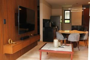 a living room with a table and a tv and a kitchen at Exclusive Boutique Apartment in Mérida Norte in Mérida
