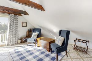 a living room with two chairs and a table at Oceanfront house with dock, kayaks, deck, and gas grill in Boothbay Harbor