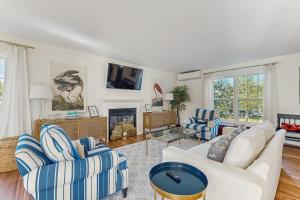 a living room with two couches and a fireplace at Newly Renovated Charming House with Cozy Fireplace & Outdoor Entertainment Areas in Rockport