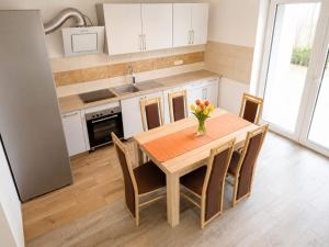 a kitchen with a wooden table and chairs in a kitchen at Landhaus Klein Markow in Jördenstorf