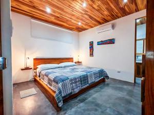 a bedroom with a bed and a wooden ceiling at Samara by the River Vacation Suites in Sámara