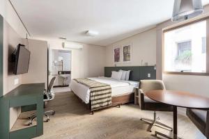 a bedroom with a bed and a desk and a table at Living Sion in Belo Horizonte +23 photos