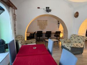 a dining room with a red table and chairs at CoZi at Dar Faiza in Houmt Souk