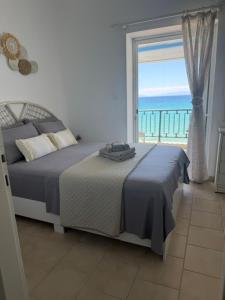 a bedroom with a bed with a view of the ocean at Seafront Maisonette in Fourka in Fourka