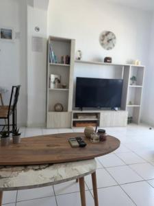 a living room with a table and a flat screen tv at Seafront Maisonette in Fourka in Fourka