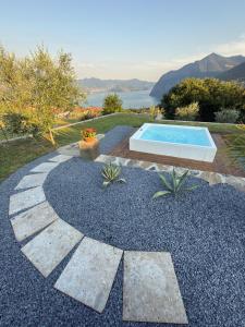 a backyard with a swimming pool and a rock garden at Corte Furmignano in Solto Collina