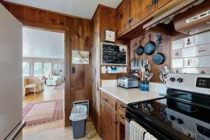 a kitchen with wooden walls and a stove top oven at Beachfront Delight with detached guesthouse, private beach access, Dog-friendly in Southport