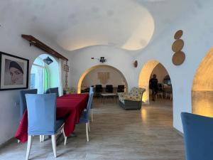 a dining room with a red table and blue chairs at CoZi at Dar Faiza in Houmt Souk