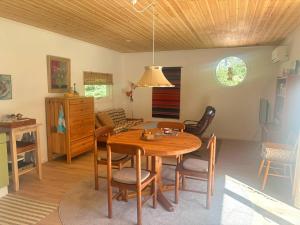 a dining room with a wooden table and chairs at Stuga Haget in Bengtsfors
