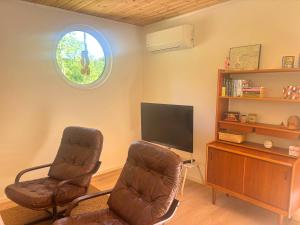 a living room with two chairs and a television at Stuga Haget in Bengtsfors