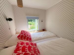 a small bedroom with two beds and a window at Stuga Haget in Bengtsfors