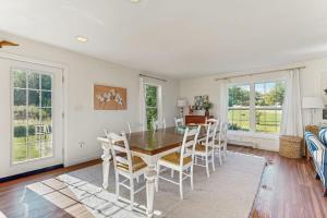a dining room with a table and chairs at Newly Renovated Charming House with Cozy Fireplace & Outdoor Entertainment Areas in Rockport
