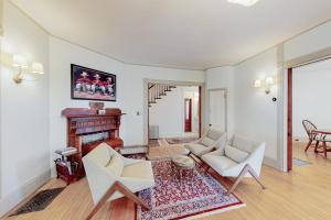 a living room with two chairs and a fireplace at Beautiful home with Ping-Pong, fast WiFi & W/D - walk to dining in Wiscasset +30 photos