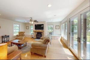 a living room filled with furniture and a tv at Secluded lakefront home with patio & firepit, fast WiFi, wood stove & W/D in Ellsworth