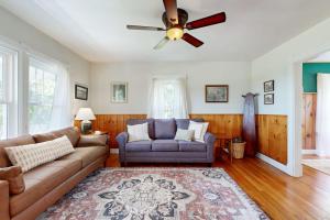 a living room with a couch and a ceiling fan at Charming Coastal Retreat with Ocean Views, Porch and Private Cabin in Sullivan