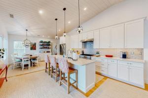 a kitchen with white cabinets and a table with chairs at Perfectly Located Retreat with Grill, Fireplace, & Chef in Boothbay Harbor