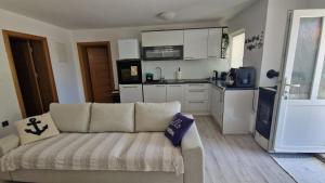 a living room with a couch and a kitchen at Apartman Jurjević in Krk