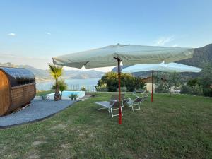 a table and chairs under an umbrella in a field at Corte Furmignano in Solto Collina +30 photos