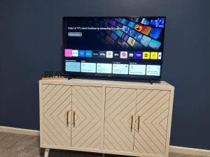 a flat screen tv sitting on top of a wooden cabinet at Elegant luxurious paradise in Decatur