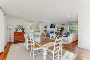 a dining room and living room with a table and chairs at Newly Renovated Charming House with Cozy Fireplace & Outdoor Entertainment Areas in Rockport