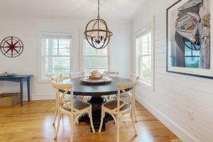 a dining room with a black table and chairs at Elegant home with veranda & water view, walk to downtown Boothbay Harbor in Boothbay Harbor