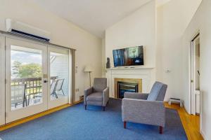 a living room with two chairs and a fireplace at Family & Dog-Friendly Townhouse w/Back Porch, Views, Partial AC in Bar Harbor