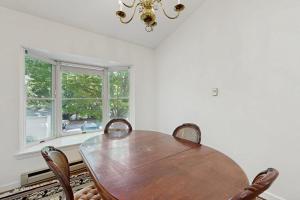 a dining room with a wooden table and chairs at Bay View Dog-Friendly Townhouse w/Porch, Gas Grill, Washer/Dryer, Partial A/C in Bar Harbor