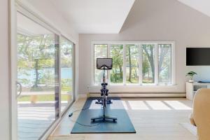a camera on a tripod in a room with windows at Water-view retreat with beach access, deck, grill, EV charger & lawn games in North Harpswell