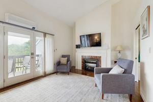 a living room with a couch and a fireplace at Newly-furnished condo with loft, fast WiFi, partial AC, grills & yard access in Bar Harbor