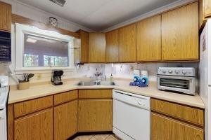 a kitchen with wooden cabinets and a sink at Lakefront Home with Private Dock, Pebble Beach & Enclosed Porch - Dogs Welcome in Greenville Junction
