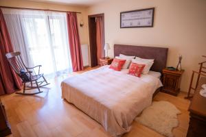 a bedroom with a large bed with red pillows at Transylvanian Villa in Predeal