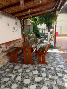 a wooden bench sitting under a pergola at Casa OZZY&PATTY in 2 Mai
