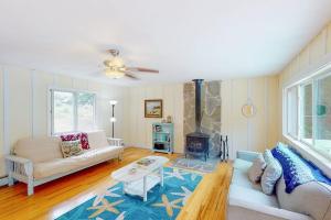 a living room with a couch and a fireplace at Waterfront home with deck, patio, grill, firepit, Ping-Pong, & WiFi in Somesville
