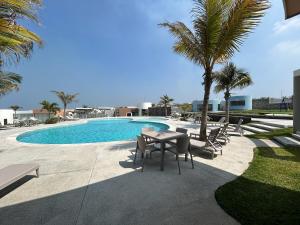 a patio with a table and chairs next to a pool at Private pool house near the beach in Heroica Alvarado