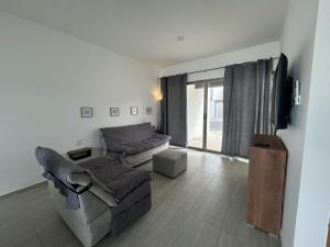 a living room with a couch and a tv at Private pool house near the beach in Heroica Alvarado