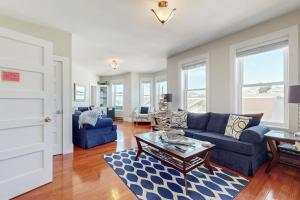 a living room with a blue couch and a table at Admiral's Quarters in Boothbay Harbor