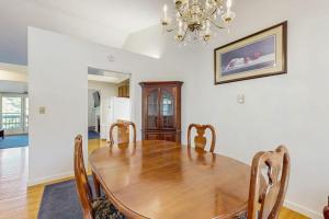 a dining room with a wooden table and a chandelier at Family & Dog-Friendly Townhouse w/Back Porch, Views, Partial AC in Bar Harbor