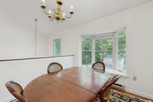 a dining room with a wooden table and chairs at Bay View Dog-Friendly Townhouse w/Porch, Gas Grill, Washer/Dryer, Partial A/C in Bar Harbor