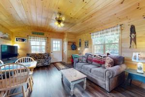 a living room with a couch and a tv at Cozy Cabin with Ocean and Mountain Views, Free Internet in Sullivan