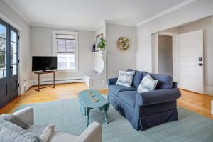 a living room with a blue couch and a table at Waterfront, walkable, updated home with harbor views & partial AC in Camden