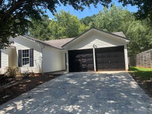 a white house with a garage with a driveway at Elegant luxurious paradise in Decatur