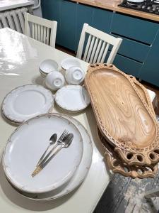 a table with white plates and utensils on it at Zirek House in Bishkek