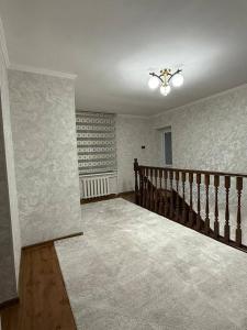 a room with a staircase and a ceiling fan at Zirek House in Bishkek