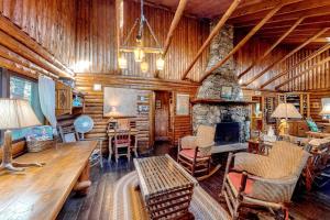 a living room with a stone fireplace in a log cabin at Stunning log cabin with fireplace & nature views - near shopping & dining in Boothbay Harbor