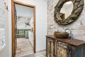 a bathroom with a sink and a mirror on the wall at Habitat Apartments in Kraków
