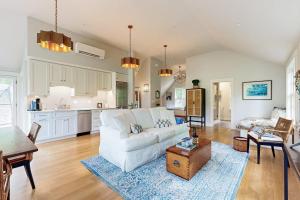 a living room with a white couch and a table at Brand new guest apartment with furnished deck, fast WIFI, dock, & water views in Boothbay Harbor