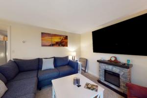 a living room with a couch and a fireplace at Serene home with a deck, grill, firepit, board games, washer/dryer, & mtn views in East Lamoine